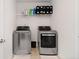 Bright laundry room with stainless steel washer and dryer and overhead storage at 3478 Spring Place Ct, Loganville, GA 30052