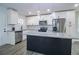 Well-lit kitchen with stainless appliances, white cabinets, granite counters, tile backsplash, and a black kitchen island at 3762 Larkspur Ter, Decatur, GA 30032