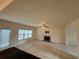 Spacious living room with neutral carpet, ceiling fan, fireplace, and views of the backyard at 3963 Lucas Ln, Ellenwood, GA 30294