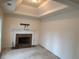 Spacious living room with a tray ceiling and fireplace featuring a brown marble hearth at 3963 Lucas Ln, Ellenwood, GA 30294