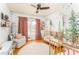 Bright Bedroom featuring a woodland mural, twin cribs, and a comfortable rocking chair at 4162 Brownlee Dr, Tucker, GA 30084