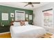 Bright bedroom with white bedding, green accent wall, and natural light from two windows at 4162 Brownlee Dr, Tucker, GA 30084