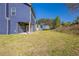 Spacious backyard with lush green grass, a covered porch, and a view of surrounding trees, perfect for outdoor activities at 417 Flowery Branch Ct, Villa Rica, GA 30180