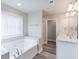 Bright bathroom featuring double sink vanity, soaking tub, and modern fixtures at 417 Flowery Branch Ct, Villa Rica, GA 30180