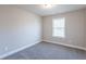 Comfortable carpeted bedroom with window and neutral color scheme at 417 Flowery Branch Ct, Villa Rica, GA 30180