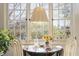 A sunlit dining area, showing a table set with flowers, framed by large windows offering a view of greenery at 1 S Prado Ne # 15, Atlanta, GA 30309