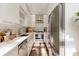 Modern galley kitchen equipped with stainless steel appliances, white cabinetry, and hardwood floors at 1 S Prado Ne # 15, Atlanta, GA 30309