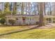 Charming single-story home with a carport and well-manicured lawn and an inviting red front door at 3475 Glensford Dr, Decatur, GA 30032