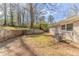Spacious backyard showing the home's exterior with mature trees at 3475 Glensford Dr, Decatur, GA 30032