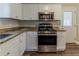 Modern kitchen featuring stainless steel appliances, granite countertops, and white cabinetry at 3475 Glensford Dr, Decatur, GA 30032
