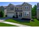 Inviting two-story home with a manicured lawn, enhanced by lush greenery and an attached two-car garage at 1218 Lanier Springs Dr, Buford, GA 30518