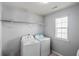 Functional laundry room with modern washer and dryer units and shelving at 1218 Lanier Springs Dr, Buford, GA 30518