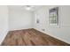 A bright, empty bedroom featuring hardwood floors, two windows, and neutral wall paint at 460 Stockwood Dr, Woodstock, GA 30188