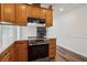 Kitchen featuring stainless steel appliances, wood cabinets, light countertops, and access to the fireplace at 460 Stockwood Dr, Woodstock, GA 30188