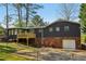 A view of the home's back exterior, with a deck, brick foundation, and attached garage at 460 Stockwood Dr, Woodstock, GA 30188