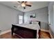 Bedroom features wood floors, ceiling fan, and a large queen bed dressed with white linens at 9 Oatgrass Dr, Grayson, GA 30017