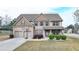 Charming two-story home with a well-manicured lawn, two car garage and a basketball hoop at 9 Oatgrass Dr, Grayson, GA 30017