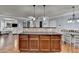 Kitchen island with dark wood cabinetry, tile backsplash, and pendant lighting open to the living room at 9 Oatgrass Dr, Grayson, GA 30017