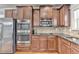 Chef's kitchen featuring stainless steel appliances, stone countertops, and custom cabinetry at 9 Oatgrass Dr, Grayson, GA 30017