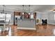 Cozy living space featuring hardwood floors, modern lighting, fireplace, and open layout to the kitchen at 9 Oatgrass Dr, Grayson, GA 30017
