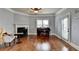 Bright living room features a fireplace, ceiling fan, and a piano with beautiful hardwood floors at 9 Oatgrass Dr, Grayson, GA 30017
