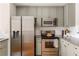 Kitchen features stainless steel appliances, gray-green cabinetry, light countertops, and white backsplash at 951 Glenwood Se Ave # 3104, Atlanta, GA 30316