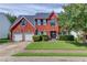Charming two-story red brick home with well-maintained lawn, two-car garage, and landscaped front yard at 1312 Woodland View Rd, Lawrenceville, GA 30043