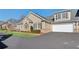 Attractive townhome features a well-maintained lawn, brick accents, and a two-car garage at 2565 Grapevine Cir # 103, Cumming, GA 30041