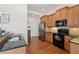 Kitchen area with wooden cabinets, black appliances, and granite counters at 2565 Grapevine Cir # 103, Cumming, GA 30041