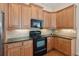 Kitchen with light-colored wooden cabinets, dark countertops, and black appliances at 2565 Grapevine Cir # 103, Cumming, GA 30041