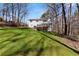 Expansive backyard with lush green grass and mature trees that provides a private setting at 400 Surveyors Pt, Suwanee, GA 30024