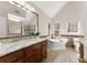 Bright bathroom featuring a soaking tub, double vanities, granite countertops, and a separate shower at 400 Surveyors Pt, Suwanee, GA 30024