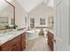 Bright bathroom featuring a soaking tub, double vanities, granite countertops, and a separate shower at 400 Surveyors Pt, Suwanee, GA 30024