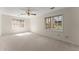 Bright bedroom featuring two windows, neutral paint, light carpeting, and a ceiling fan at 400 Surveyors Pt, Suwanee, GA 30024