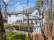 Rear exterior view of the home with a spacious deck and patio, surrounded by lush greenery and mature trees at 400 Surveyors Pt, Suwanee, GA 30024