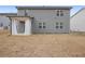 A gray home's backyard features a covered patio and spacious lawn at 5 Dew Drop Pt, Dallas, GA 30157