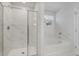 This bathroom has a glass shower, a tub, and marble-patterned tile at 5 Dew Drop Pt, Dallas, GA 30157