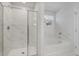 Modern bathroom with glass enclosed shower and soaking tub surrounded by marble tile at 5 Dew Drop Pt, Dallas, GA 30157