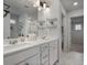 Bright bathroom with double vanity, elegant mirrors, open shelving, and modern fixtures at 5 Dew Drop Pt, Dallas, GA 30157