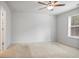 This bedroom features neutral walls, carpet, a ceiling fan, and a window for natural light at 5 Dew Drop Pt, Dallas, GA 30157