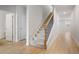 Hallway with light wood floors leads to stairs with carpet, featuring white walls and doors at 5 Dew Drop Pt, Dallas, GA 30157