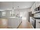 Bright, eat-in kitchen features an island with sink, white cabinetry, stainless appliances, and modern pendant lighting at 5 Dew Drop Pt, Dallas, GA 30157