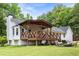 Spacious backyard featuring a covered back porch and outdoor seating, surrounded by lush trees and greenery at 511 Laird Rd, Hiram, GA 30141
