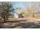 Expansive yard with white home, wooden deck and plenty of mature trees offering shade at 511 Laird Rd, Hiram, GA 30141