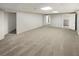 Finished basement area featuring neutral carpet, bright lighting, and access to other rooms at 2688 Kelly Cove Dr, Buford, GA 30519