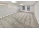 Spacious finished basement with neutral carpet, bright lighting, and two windows at 2688 Kelly Cove Dr, Buford, GA 30519