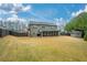 Expansive backyard view showcasing the home's exterior, a screened porch, a shed, and ample green space at 4030 Amberhill Cir, Cumming, GA 30040