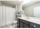 Bright bathroom with a white shower curtain, vanity with dark cabinets, and a decorative stack of towels at 4030 Amberhill Cir, Cumming, GA 30040