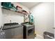 Laundry room featuring modern side-by-side washer and dryer with wire shelves at 4030 Amberhill Cir, Cumming, GA 30040