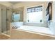 Bright bathroom features a walk-in shower and a soaking tub next to a window at 4030 Amberhill Cir, Cumming, GA 30040